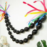 Colorful balloon garland decoration with black and vibrant accent balloons.