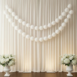 White balloons draped elegantly over a soft cream curtain with floral arrangements.