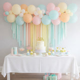 Pastel balloon decor with a birthday cake and dessert table setting.