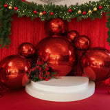 Red holiday decorations with large shiny ornaments and a floral arrangement.