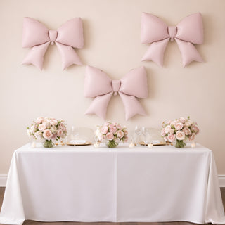 Elegant pink bows and floral centerpieces on a decorated table for an event.
