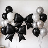 Black and silver balloon bouquet with large star-shaped bows.