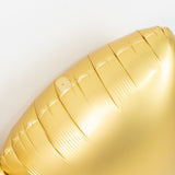 Gold foil balloon close-up, showcasing shiny texture and details.