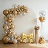 Elegant gold balloon arch with floral accents and a shiny bow decoration.