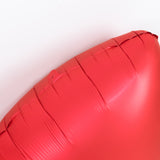 Red heart-shaped balloon on a plain background