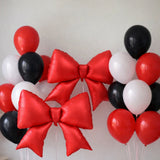 Red and black balloon bouquet with large red bow-shaped balloons.