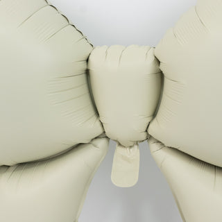 Beige inflatable bow balloon on a white background