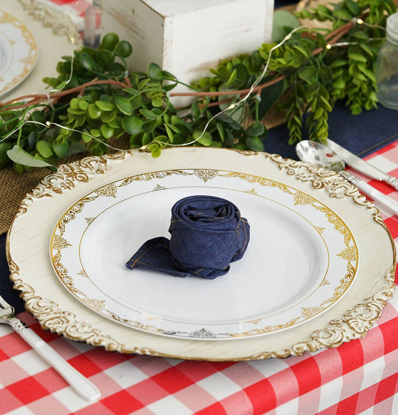 White plate with gold trim and folded navy napkin