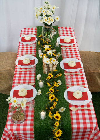 Outdoor table with red checkered tablecloth and flower centerpiece