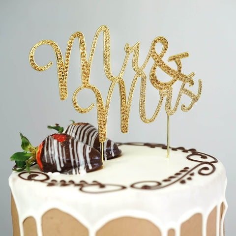 Gold glitter cake topper on a wedding cake