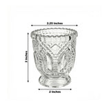 Lit glass candle holder with warm candlelight and green eucalyptus leaves