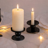 Black candle holders with ivory candles lit, surrounded by warm fairy lights.