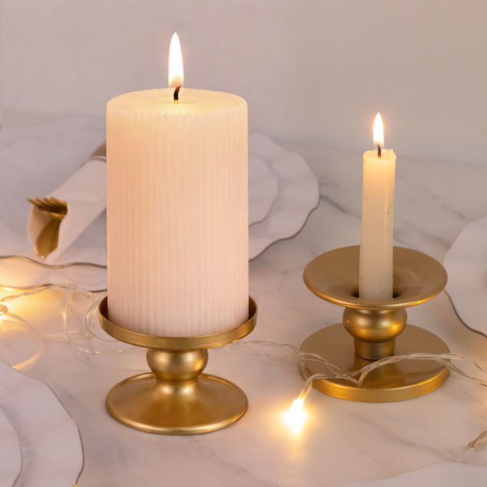 Gold candle holders with white candles and warm string lights.