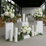 White floral arrangements and candles in a modern event space.