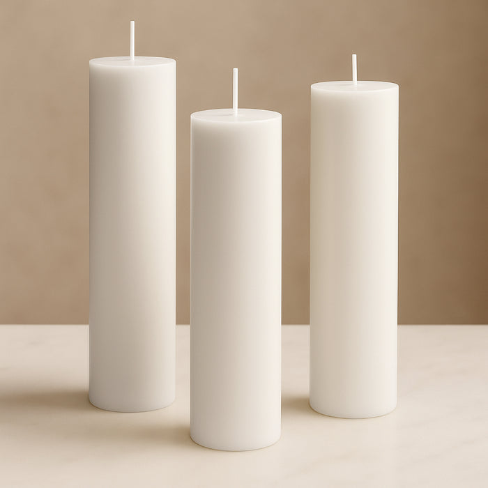 White pillar candles in varying heights against a soft beige background.
