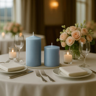 Blue candles on an elegantly set dining table with roses and glassware.