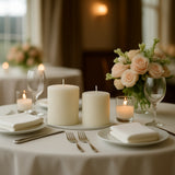 Elegant table setting with candles and floral centerpiece in soft lighting.