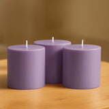 Purple pillar candles arranged on a wooden surface.