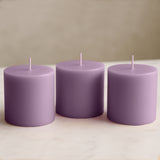 Purple pillar candles set on a marble surface.