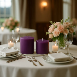 Purple candles with white table settings and a floral centerpiece in an elegant dining setting.