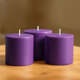 Purple cylindrical candles arranged on a wooden table.