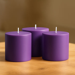 Purple cylindrical candles arranged on a wooden table.