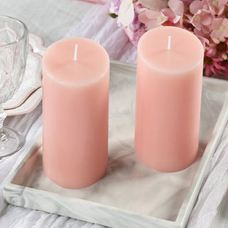 Pink pillar candles on a marble tray with floral accents.