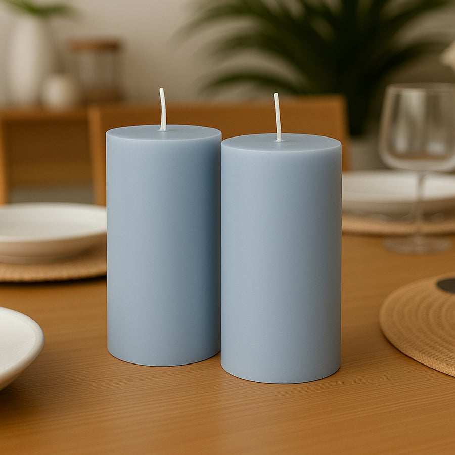 Blue pillar candles on a dining table setting.