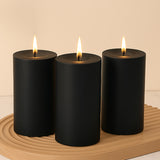 Black pillar candles with flames on a decorative wooden tray.