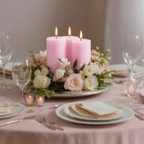 Elegant table setting with pink candles and floral arrangement.