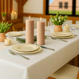 Elegant table setting with candles, plates, and greenery for a cozy dining experience.