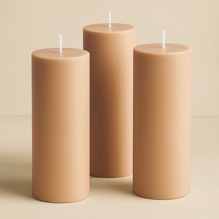 Set of three beige pillar candles in varying heights.