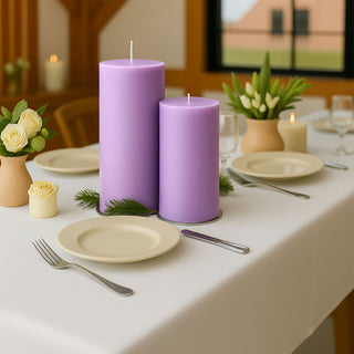 Purple decorative candles on a dining table setting with flowers and tableware.