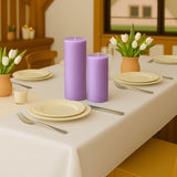 Purple candles on a dining table with tulips and dinnerware.