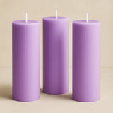 Purple pillar candles set of three on a neutral background.