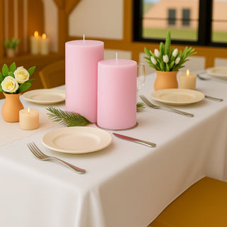 Romantic table setting with pink candles and floral arrangements.
