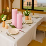 Elegant dining table setup with pink candles and floral arrangements.