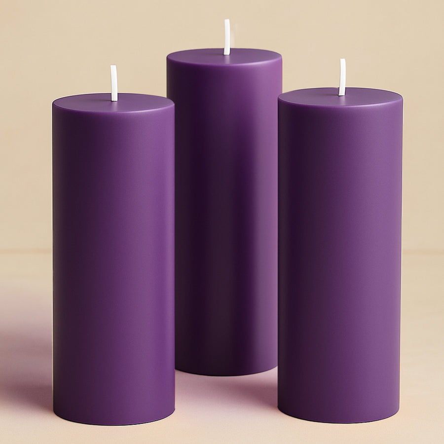 Three purple cylindrical candles in varying heights.