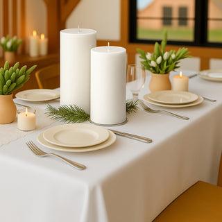 Elegant dining table setup with candles and fresh greenery.