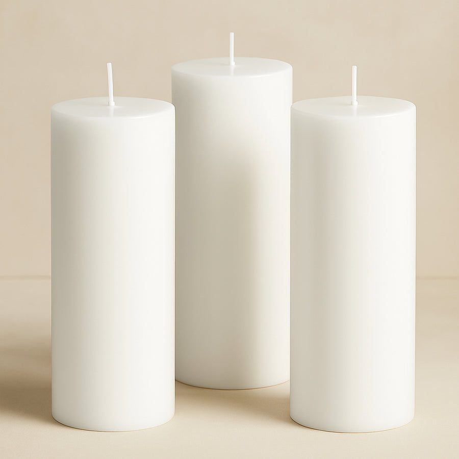Set of three elegant white pillar candles in varying heights.