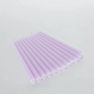 Set of 12 lavender taper candles in a studio-style isolation shot.