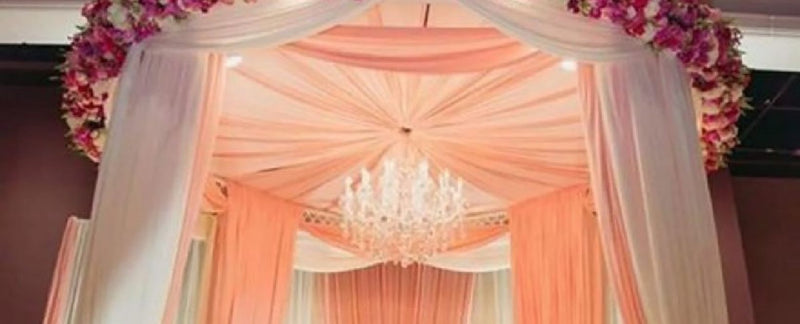 White draped ceiling with pink floral arch