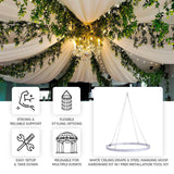 White ceiling drape kit with soft fabric swags, greenery garlands, and chandelier lighting, creat...
