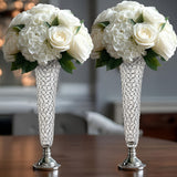 Elegant floral arrangements in crystal vases on a wooden table.