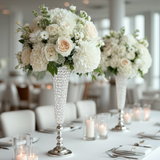 Elegant white floral arrangements in crystal vases on a dining table.