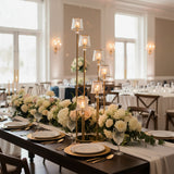 Elegant table setting with floral centerpieces and candle holders for a wedding.