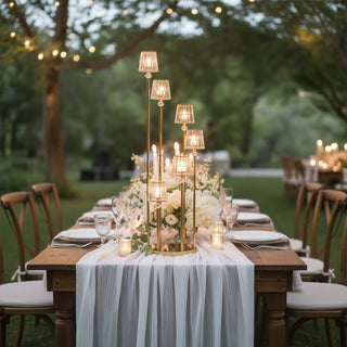 Elegant outdoor dining setup with candles and floral centerpiece.
