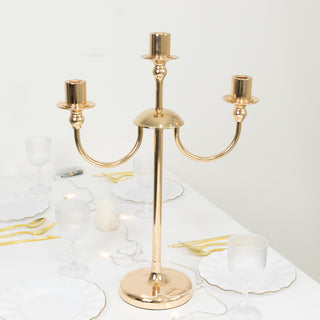 Gold three-arm candelabra centerpiece on a table setting.