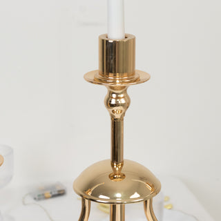 Elegant gold candle holder with a sleek design and a white candle.