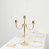 Elegant gold candelabra with three candles on a dining table